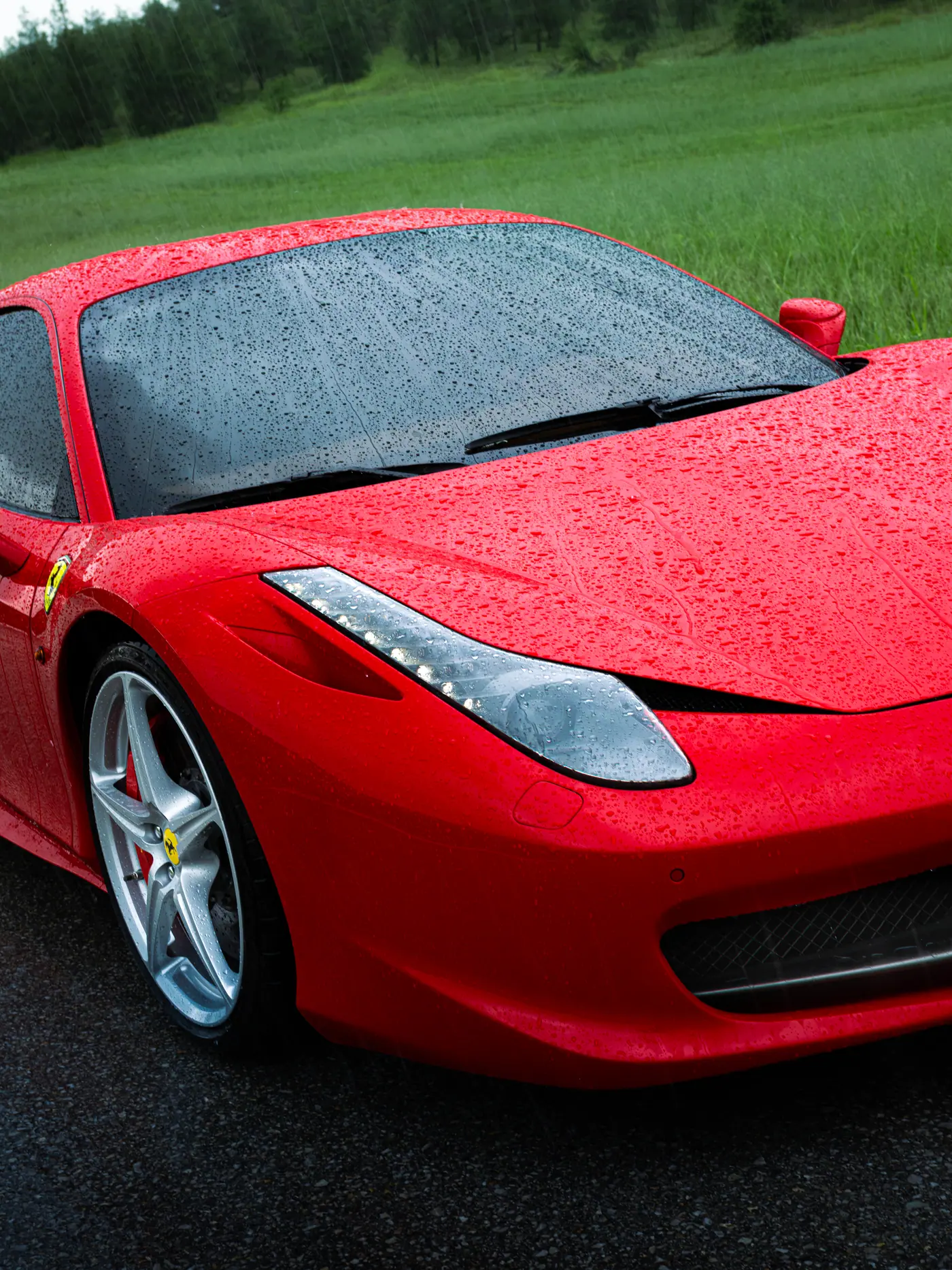 Yağmur altında kırmızı Ferrari gövde ve far detayı