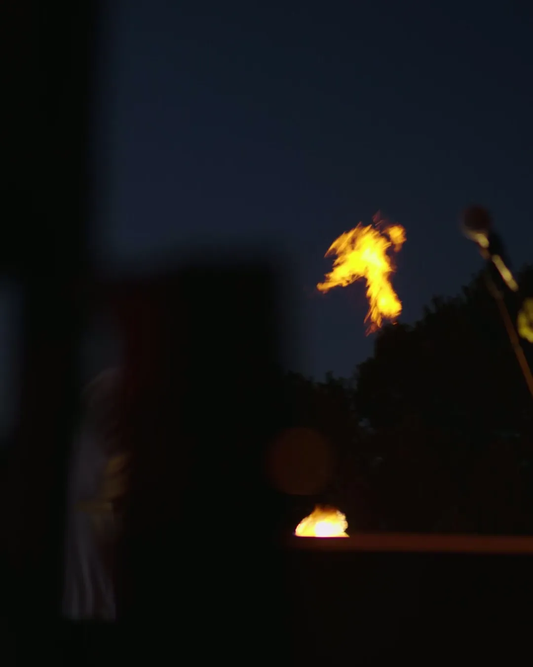 Summer Heat'te gece, ağaçların üstünde yükselen alev