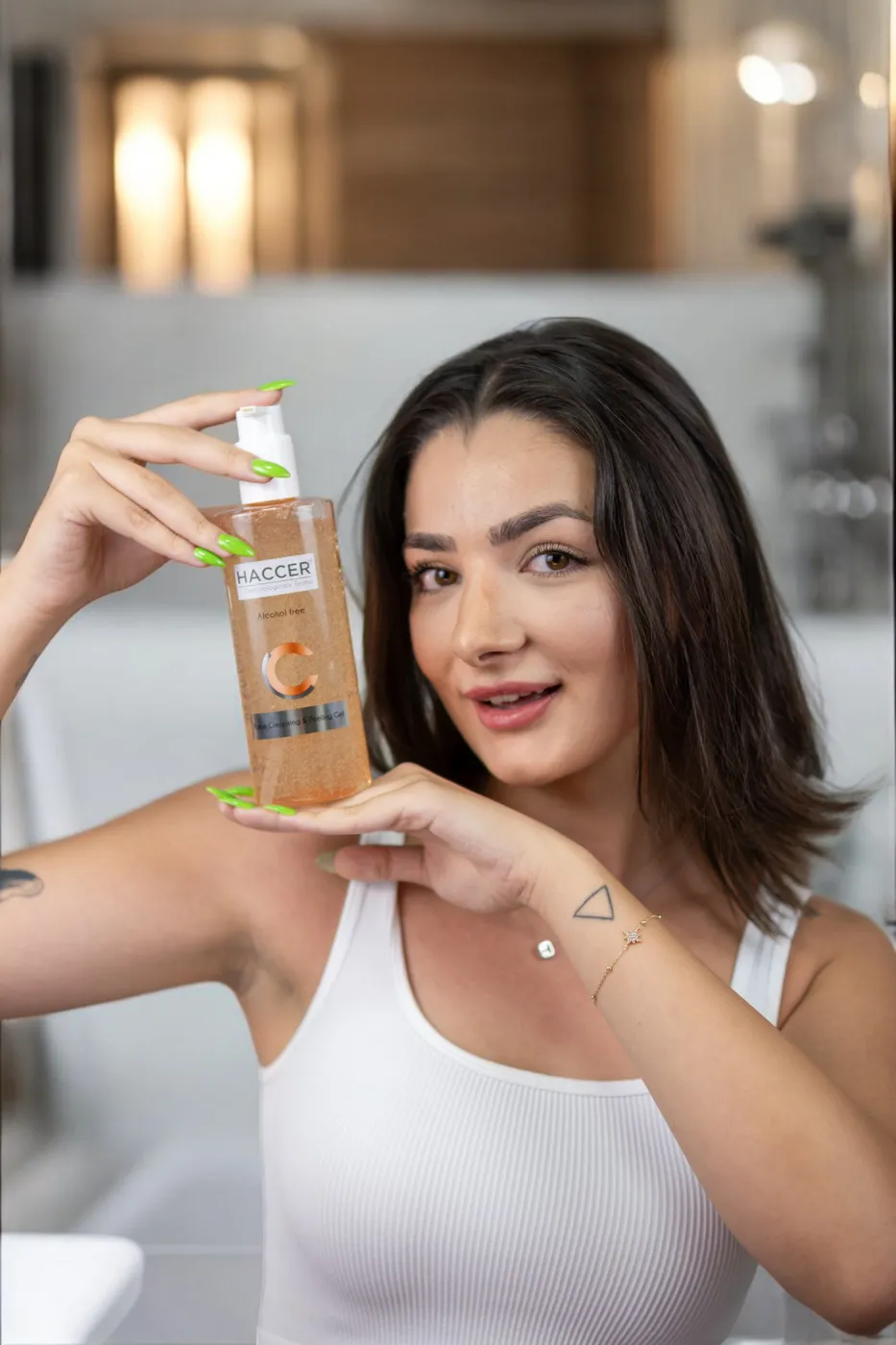 Banyoda, elindeki serum şişesini kameraya gösteren model